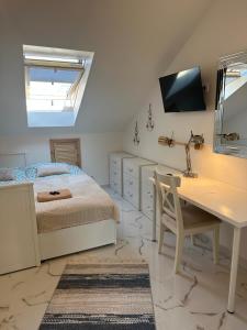 a bedroom with a bed and a desk and a mirror at Dobry Adres in Gdynia