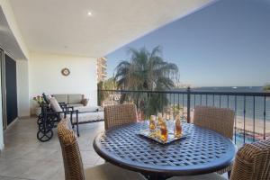 a table and chairs on a balcony with a view of the ocean at Sonoran Sky in Puerto Peñasco