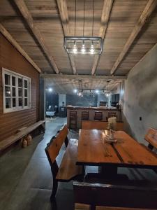 a dining room with a wooden table and benches at Pousada Rural Sitio Bela Açucena in Braço do Norte