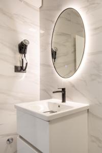a white bathroom with a sink and a mirror at Villa Kristina in Neum