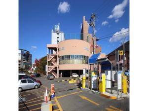 a parking lot with a gas station in front of a building at Smile Hotel Hirosaki - Vacation STAY 40509v in Hirosaki
