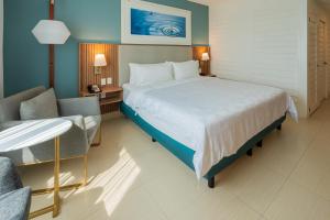a hotel room with a large bed and a chair at Holiday Inn Acapulco La Isla by IHG in Acapulco