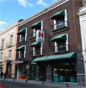 a building with a hotel sign on the side of it at Hotel Victoria in Puebla