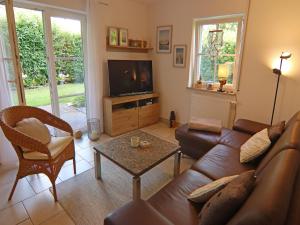 グラール・ミューリッツにあるModerne Ferienwohnung in Graal-Müritz, strandnahのソファとテレビのあるリビングルーム