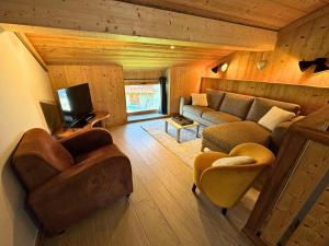 a living room with a couch and chairs and a tv at Chalet Aster - Maison de village rénovée sur 3 niveaux 4 pièces pour 6 personnes à St Marcel MAE-6444 in Saint-Marcel
