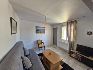 a living room with a couch and a table at Les Bleuets in Saint Martin de Brehal