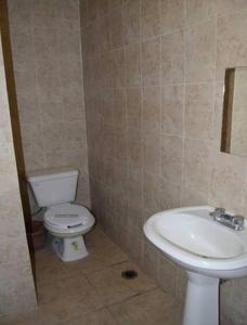 a bathroom with a toilet and a sink at Hotel Victoria in Puebla