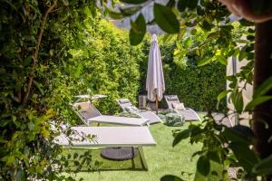a group of chairs and an umbrella in the grass at Luxury Panoramic Loft with heated saltwater pool and parking near Taormina, Catania, the Sea and Mount Etna by SicilianRelaxingHomes in Giarre