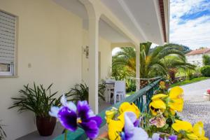 a porch with yellow and purple flowers on it at Escondidinho do Vez, LDA in Arcos de Valdevez