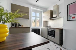 a kitchen with a wooden table and a counter top at Blick Apartments - Soft Loft in Zgorzelec
