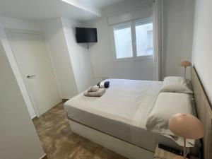 una camera da letto con un grande letto bianco con una finestra di ESPECTACULAR DUPLEX en el CENTRO a Gandía