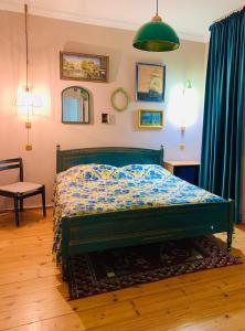 ein Schlafzimmer mit einem Bett mit einer blauen Bettdecke in der Unterkunft Vintage 4BR Borjomi Hideaway in Itʼkhvisi