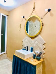 ein Badezimmer mit Waschbecken und Spiegel an der Wand in der Unterkunft Vintage 4BR Borjomi Hideaway in Itʼkhvisi