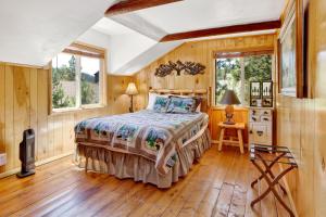 een slaapkamer met een bed in een kamer met houten wanden bij Circle views #1602 in Big Bear Lake