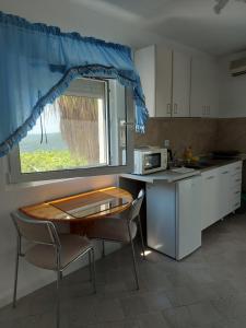 a kitchen with a table and chairs and a window at Apartments Nikvik in Budva +18 photos