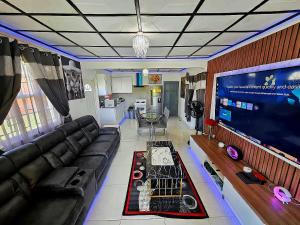 基督教堂市Sunrise Haven Holiday Apartments Barbados的带沙发和大电视的客厅