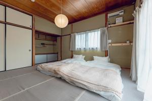 中津川市にあるえなや中津川の木製の天井と大きなベッドのある寝室