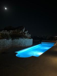 a swimming pool lit up at night at Great house for quiet and relaxing in Ano Mera