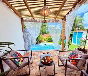 a patio with a table and chairs and a pool at Géko, piscine, jardin, paisible in Sainte-Luce
