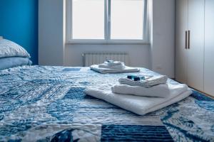 a bed with towels sitting on top of it at Genova Host - Una Finestra sul Mare in Genova