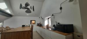 a kitchen with a counter with a tv on the wall at Chambre spacieuse avec piscine privative in Plaintel