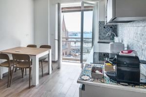 a kitchen with a table and a counter top at Genova Host - Una Finestra sul Mare in Genova