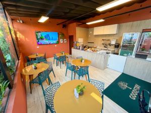 a restaurant with tables and chairs and a kitchen at GoodStay São Paulo Ibirapuera in São Paulo