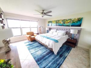 Un dormitorio con una cama grande y un ventilador de techo. en Sand Dollar 101, en St. Augustine