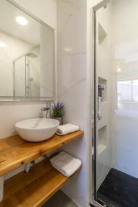 a white bathroom with a sink and a shower at Ericeira - Casa Tia Alice in Ericeira +16 photos
