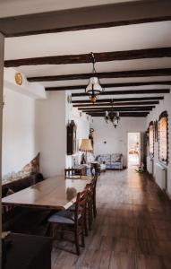 a kitchen and dining room with a table and chairs at Casa pe Valea Hartibaciului(Bărcuț) in Bărcuţ