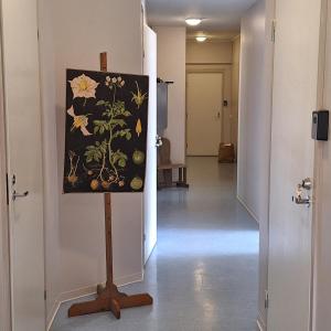 a painting on a stand in a hallway at Koulumestarin majoitus 