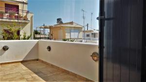 a door to a balcony with a view of a house at Dionysus Blue Sky in Egina