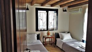 a bedroom with two beds and a window at Dionysus Blue Sky in Egina