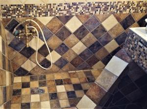 a bathroom with a shower with a tiled wall at Dionysus Blue Sky in Egina +26 photos
