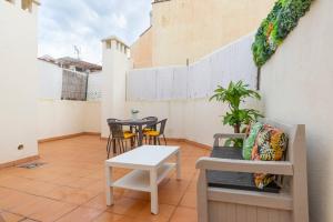 マラガにあるCentral Penthouse Apartmentのバルコニーにテーブルと椅子が置かれたパティオ