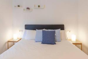 マラガにあるCentral Penthouse Apartmentの白いベッドと青い枕のある寝室