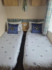 two beds with blue pillows in a room at 89 Main Park , Lilliardsedge in Harrietsfield
