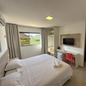 a bedroom with a bed and a desk and a television at Felipe Hotel in Serra Talhada +51 photos