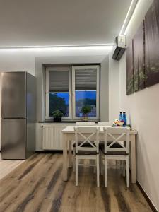 a kitchen with a table and two chairs and a refrigerator at Mieszkanie in Bolesławiec +18 photos