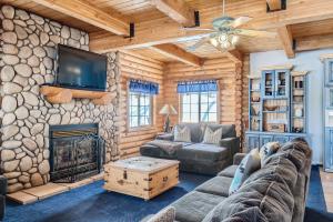 sala de estar con chimenea y pared de piedra en 6 Bedroom Cabin by Xquisite Rentals, en Heber City