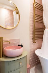 a pink bathroom with a sink and a mirror at Mill Cottage in Newlands +26 photos