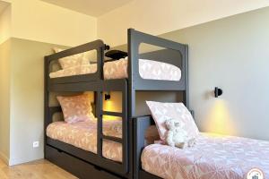 Un dormitorio con dos literas y una silla. en Le Palais des Terrasses, en Tourgéville