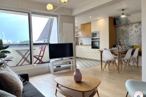 sala de estar con TV y cocina con mesa en Le Palais des Terrasses, en Tourgéville 15 fotos más