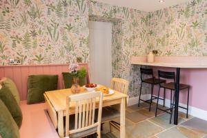 a living room with a table and chairs and a kitchen at Mill Cottage in Newlands