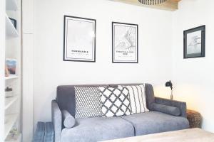 a living room with a couch and two framed pictures at La Trouvillette - 500m plage - 10mn Gare in Trouville-sur-Mer