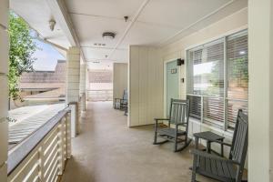 a porch with chairs and a table and windows at 529 Sunsuite in Fripp Island