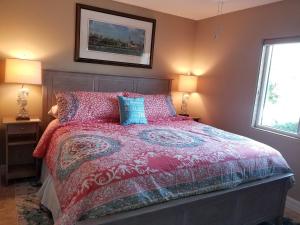 una camera da letto con un letto con un piumone rosso e due lampade di Summerhouse 101 a St. Augustine Altre 24 foto