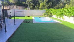 a backyard with a swimming pool and green grass at La Sudiste in Six-Fours-les-Plages