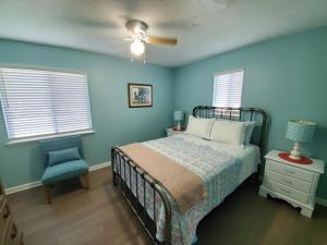 a bedroom with blue walls and a bed and a chair at Floridays in Butler Beach +28 photos