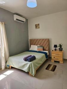 a bedroom with a bed and a night stand with a fan at Villa Gaston in Las Terrenas